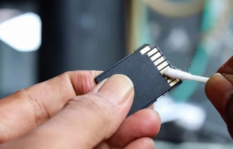 Cleaning SD memory card contacts using a cotton swab Foto stock