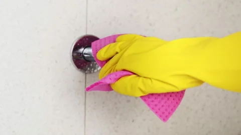 Cleaning service. Hands in protective gloves washing faucet with a spray Stock Footage 143933053