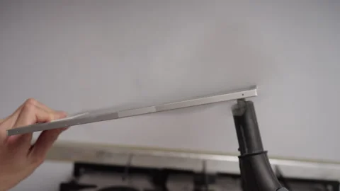 Cleaning service worker removing grease stains from kitchen hood filter using Stock Footage 306000085