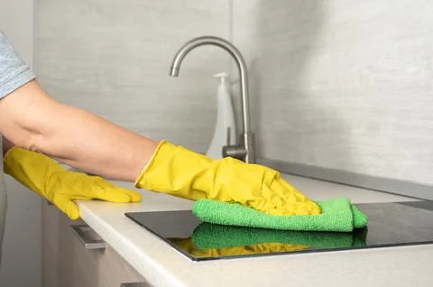 Cleaning service worker in rubber protective cleaning and polish electric coo Stock Photos