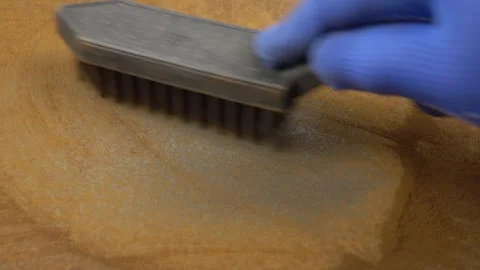 Cleaning a sheet of metal from rust with a wire brush Stock Footage 253804174