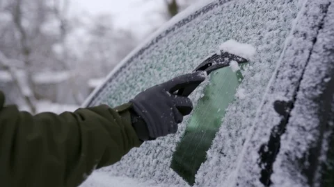 Cleaning the side car windows of snow with ice scraper before the trip. Man Video stock 119307373