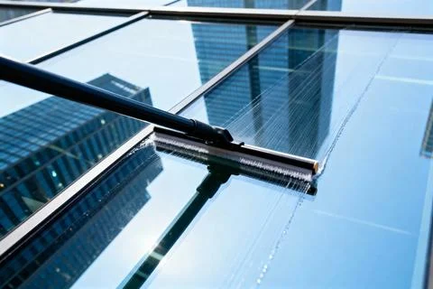 Cleaning skyscraper windows with a professional squeegee and cleaning solutio Stock Photos
