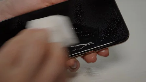 Cleaning smartphone display with spray and wet wipe Stock Footage 128446539