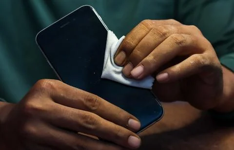 Cleaning a smartphone screen and frame Stock Photos