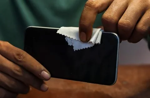Cleaning a smartphone screen and frame Stock Photos