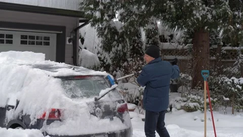 Cleaning snow off a car. Stockbeeldmateriaal 227255604
