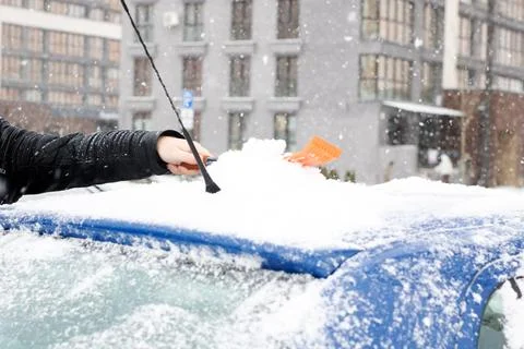 Cleaning snow off car before work. Preparing vehicle for cold morning commute in Photos