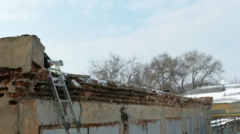 Cleaning snow from the roof of the old building. Stock Footage 59795624