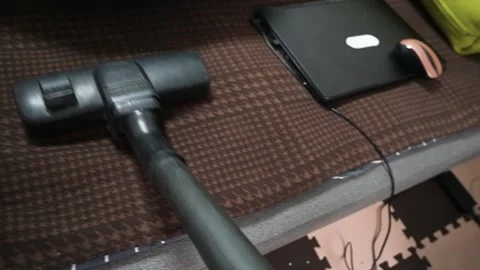 Cleaning Sofa Upholstery with Vacuum Cleaner Brush Near Laptop on Brown Fabric Stock Footage 342438253