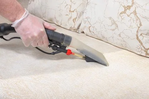 Cleaning the sofa with a vacuum cleaner Stock Photos