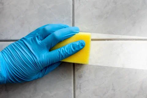 Cleaning sponge held in hand while cleaning bathroom Stock Photos