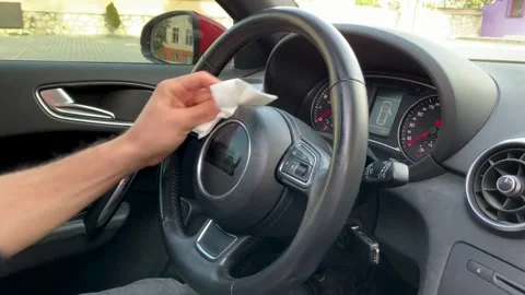 Cleaning steering wheel of a car using wet wipe from bacteria and virus. Stock-Footage 336267104