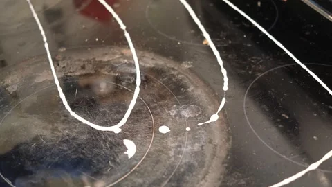 Cleaning a stove top with a solution and wiping it down. Stock-Footage 318943360