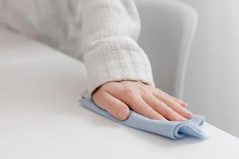 Cleaning the table with a blue microfiber cloth. Sanitize surfaces prevention in Stock Photos