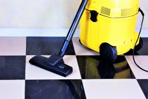Cleaning of the tile floor surface with a vacuum cleaner Stock Photos