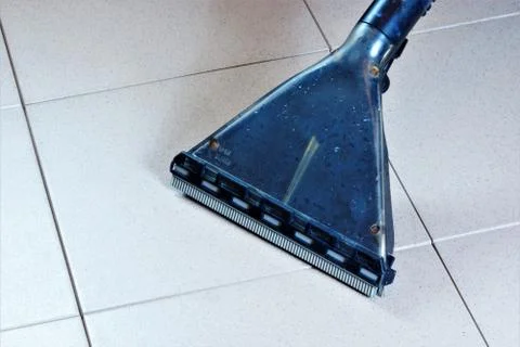 Cleaning tile floor surface wet vacuum, sanitary restoring clean of debris. Stock Photos