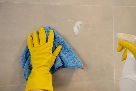 Cleaning tiled kitchen surface with spray detergent and microfiber cloth Stock Photos