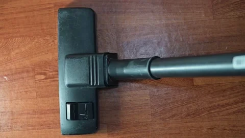 A cleaning tool attachment is positioned on a wooden surface, captured from four Stock Footage 339005131