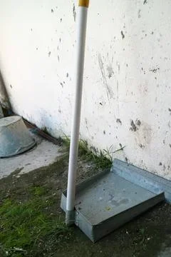 Cleaning tool with long handle and flat head on outdoor ground Photos