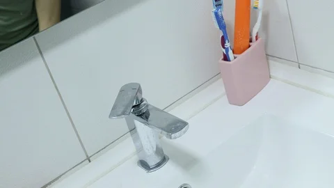 Cleaning the toothbrush in the bathroom Stock Footage 128605180