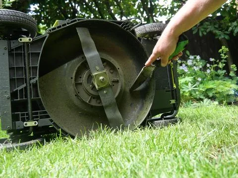 Cleaning underside of lawn mower Stock Photos