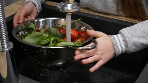 Cleaning washing vegetables in kitchen sink. Close up of men hands with greens Stock Footage 101546045