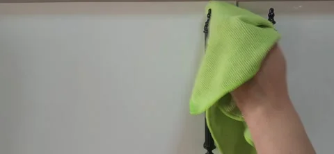 Cleaning white kitchen cabinets and black handles with a microfiber cloth. Stock Footage 334863967