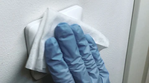 Cleaning the white switch in gloves with a white cloth, pandemic coronavirus Vídeo Stock 127935911