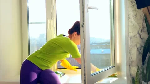 Cleaning a window Stockbeeldmateriaal 21765631