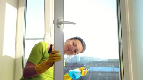 Cleaning a window Stockbeeldmateriaal 21765924
