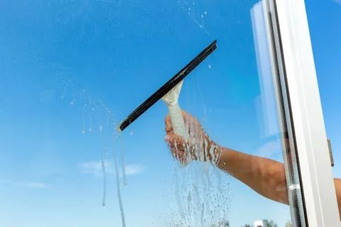 Cleaning window with special brush on the the blue sky background Stock Photos