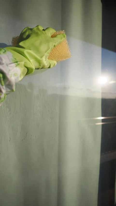 Cleaning a window with a sponge at sunset Stock Footage 341455410