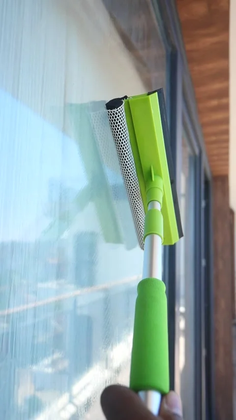 Cleaning windows with a squeegee on a sunny day Stock Footage 320211374