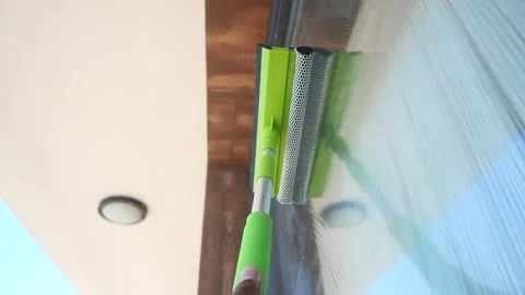 Cleaning windows with a squeegee on a sunny day Stock Footage 323246170