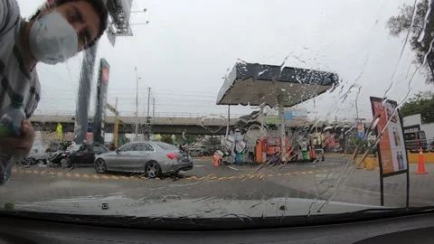 Cleaning the windshield of a car seen from the inside. washing with water Stock-Footage 147462349