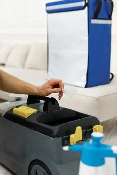 Cleaning worker in blue shirt adding chemicals in a cleaning vacuum Stock Photos