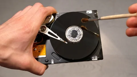 Cleans an opened hard drive with a brush Stock Footage 121535123