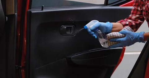 Cleansing car interior and spraying with disinfection liquid. Hands in rubber Stock-Footage 128326288
