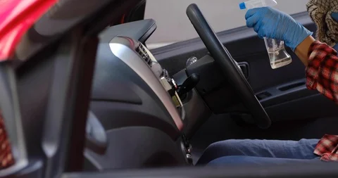 Cleansing car interior and spraying with disinfection liquid. Hands in rubber Stock-Footage 128328536