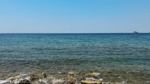 Clear Adriatic water washes over rocks along the coast of Montenegro under a Stock Footage 344903921