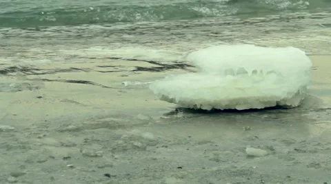 Clear block of ice lying on the sand beach. Winter sea Stock Footage 55425290