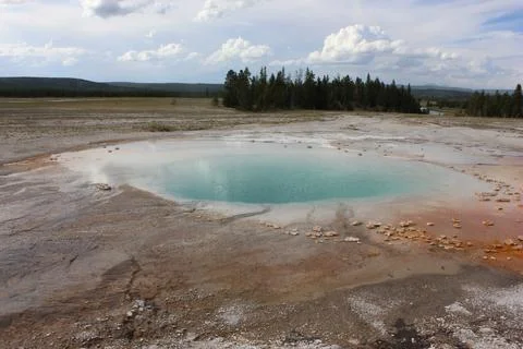 Clear blue hot spring surrounded by mineral deposits in Yellowstone Nationa.. Stock Photos