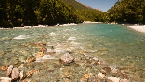 Clear, blue, mountain river flowing over a stony bed, New Zealand. Video stock 148448371
