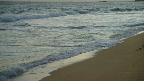 Clear blue ocean with churning waves crashing onto sandy beach on foreground Stock Footage 271172975