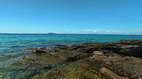 Clear blue sky above calm turquoise waters. Lagomandra, Greece 스톡 동영상 339021003