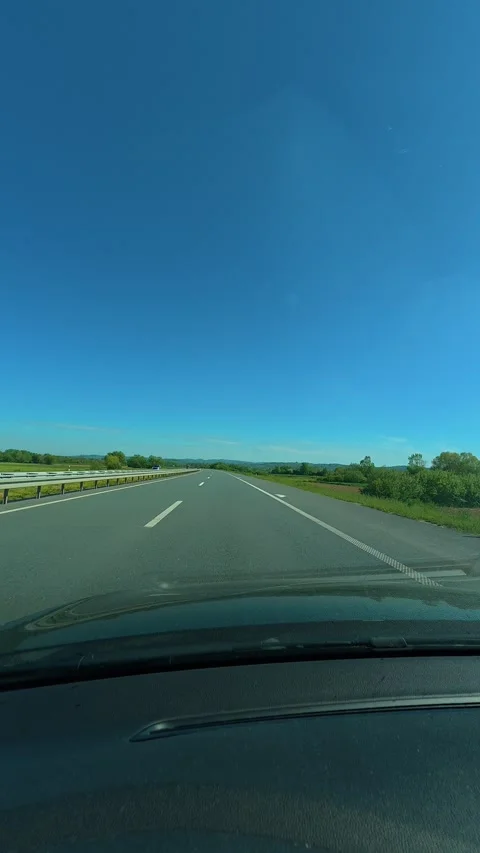 Clear blue sky above open road ahead. Balkans, Serbia. Vertical Видео 334679896
