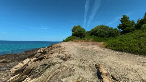 Clear blue sky above turquoise sea and rocky shore. Lagomandra, Greece Stock Footage 339021880