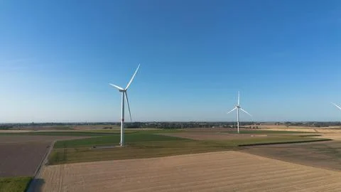 Clear blue sky above wind turbines in open fields Stock Photos