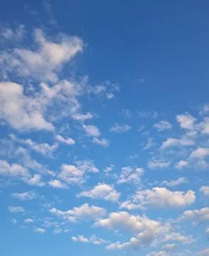 Clear blue sky with delicate small cirrus clouds scattered across it. Stock Photos